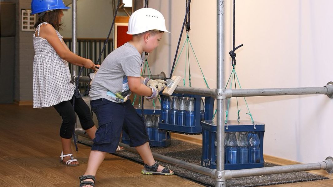 Junge am Flaschenzug mit Mineralwasserkästen